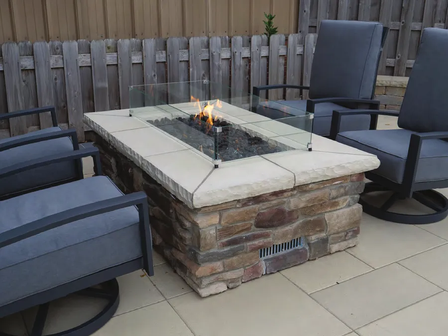 A stone fire pit finished around an Outdoor GreatRoom ready-to-finish kit