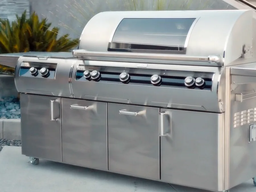A Fire Magic Echelon portable grill on a patio beside a stairway