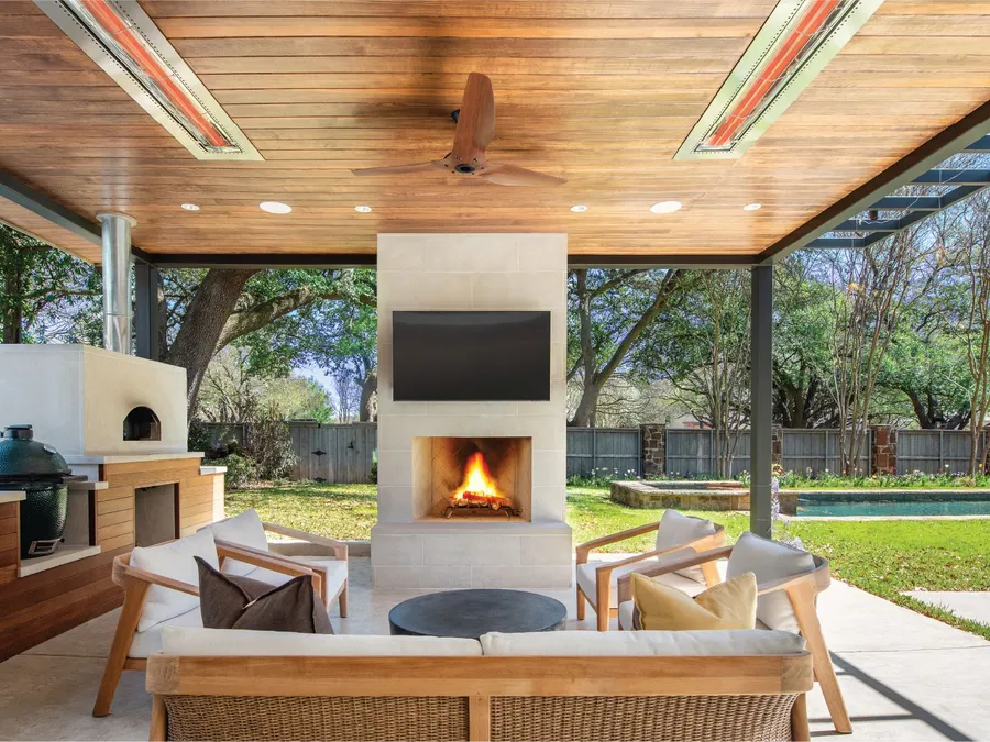 Infratech heaters glowing in the ceiling of a covered patio with an outdoor fireplace