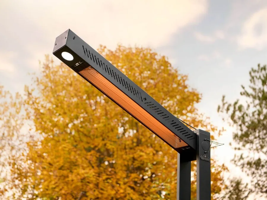A Napoleon Freestand Phantom electric heater glowing against fall trees